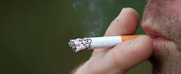 мужчина курит сигарету